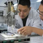 展示工程团队在洁净环境中评估窄边框手机防水胶点胶路径与出胶稳定性的工业化场景。